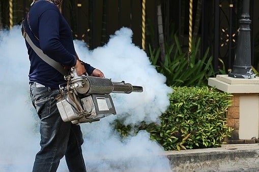Technician fogging around a garden gate